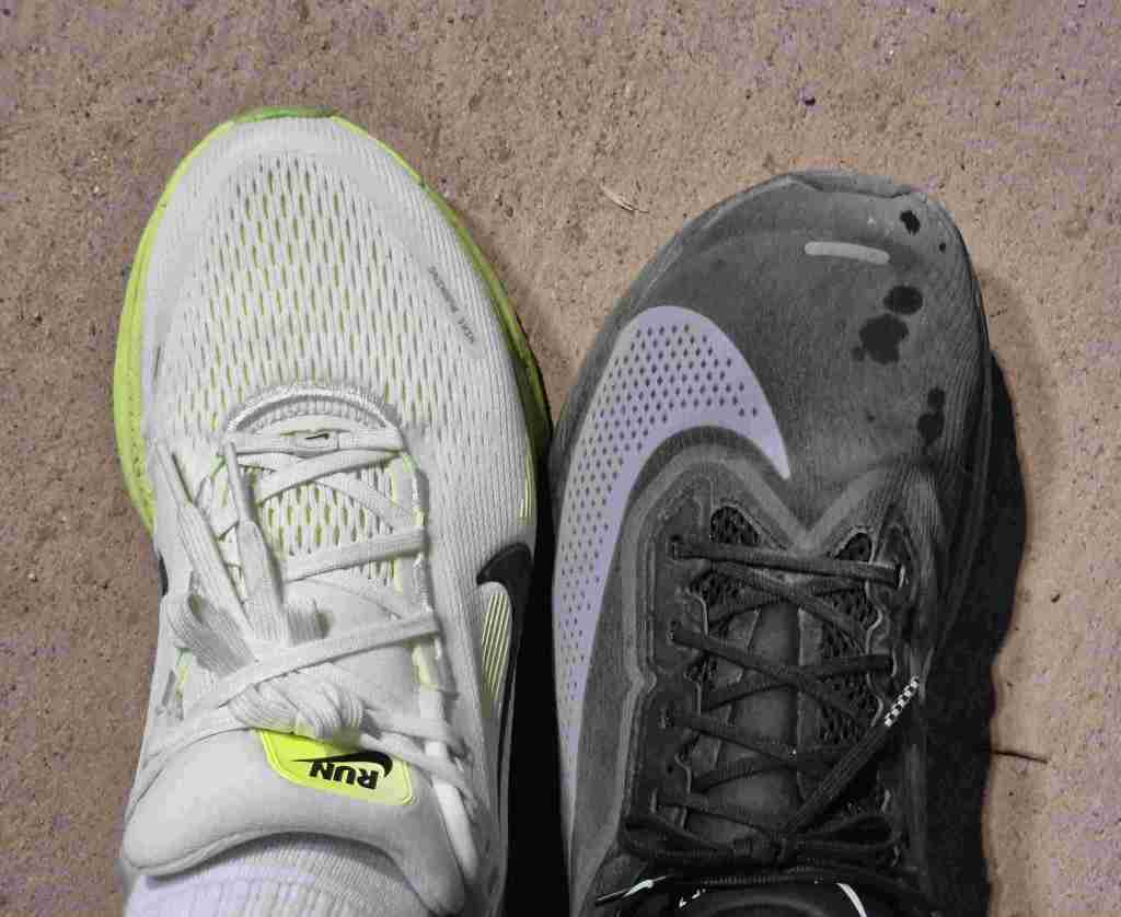 Two pairs of running shoes after a rainy night run under a riverside road.