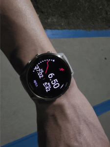 Garmin watch on my wrist showing 6.50 km after a summer run in heat and wind.